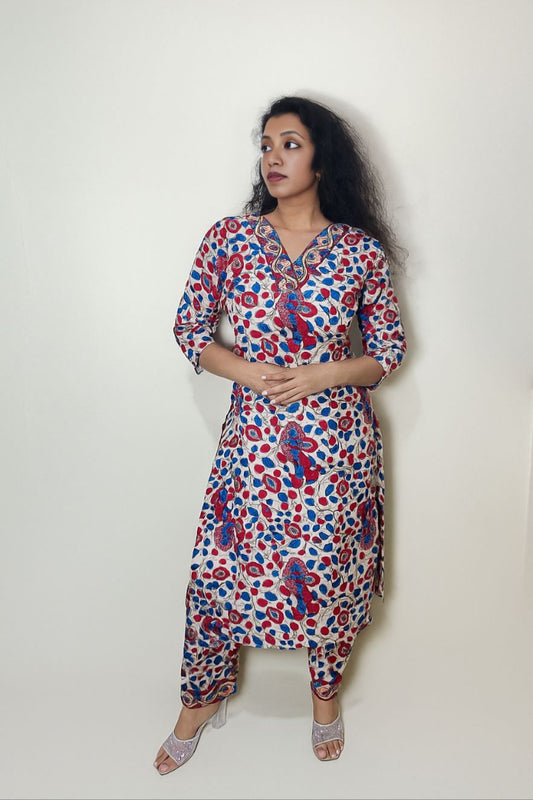 Woman wearing a colorful patterned dress against a white background